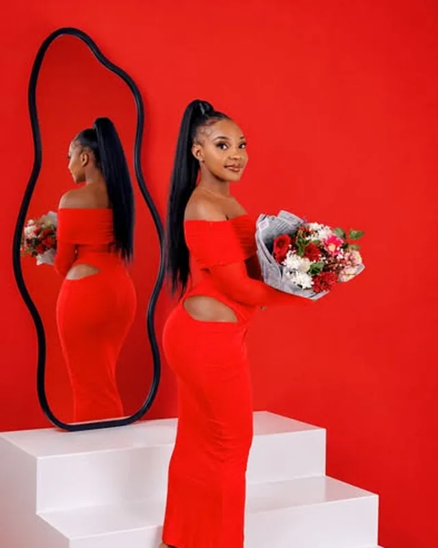 Portrait in a red dress against a red backdrop with mirror